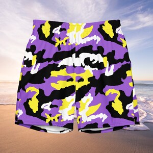 May include: Purple, yellow, black, and white camouflage print shorts. The shorts have a drawstring waistband and a relaxed fit.
