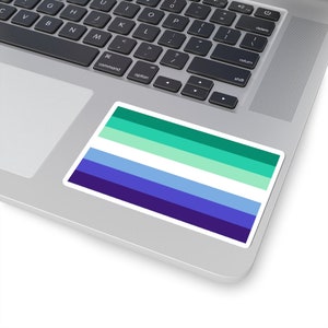 Puede incluir: Una pegatina con los colores de la bandera del orgullo gay, con rayas de color turquesa, verde claro, blanco, azul claro, azul y morado.