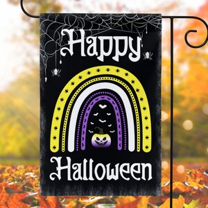 May include: A black garden flag featuring a rainbow design in yellow, white, and purple. The rainbow has a black spiderweb pattern and a pumpkin with a spooky face in the centre. The text "Happy Halloween" is written in white on the flag.