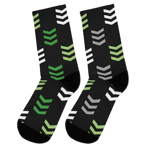 May include: A pair of black socks with a pattern of green, white, and gray arrows.