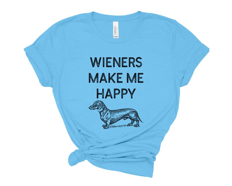 Puede incluir: Una camiseta azul claro con el texto "Wieners Make Me Happy" y una ilustraci&oacute;n en blanco y negro de un dachshund.