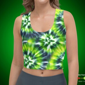 May include: A green and black tie-dye crop top with a scoop neck and thin straps. The top is made of a soft, stretchy fabric and is perfect for a casual, summery look.