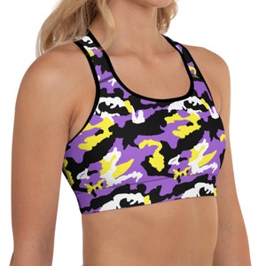 May include: A sports bra with a purple, yellow, black and white camouflage print. The bra has a racerback style and is made from a stretchy, breathable fabric.