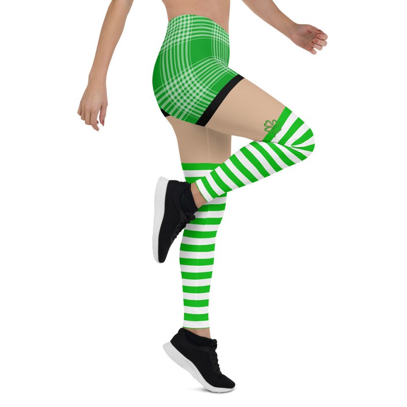 May include: Green and white plaid shorts with a black waistband and green and white striped leggings with a shamrock design. The leggings are worn with black sneakers.