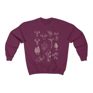 May include: A maroon sweatshirt with a white outline of various types of mushrooms printed on the front.