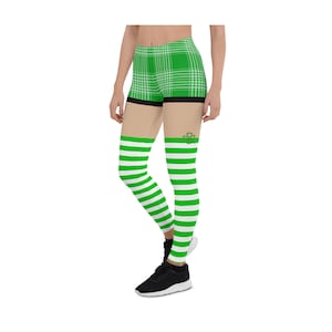 May include: Green and white striped leggings with a green plaid pattern on the top portion. The leggings have a shamrock design on the thigh.