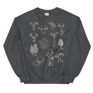May include: A dark heather grey sweatshirt with a white graphic of various types of mushrooms. The mushrooms are drawn in a vintage style.