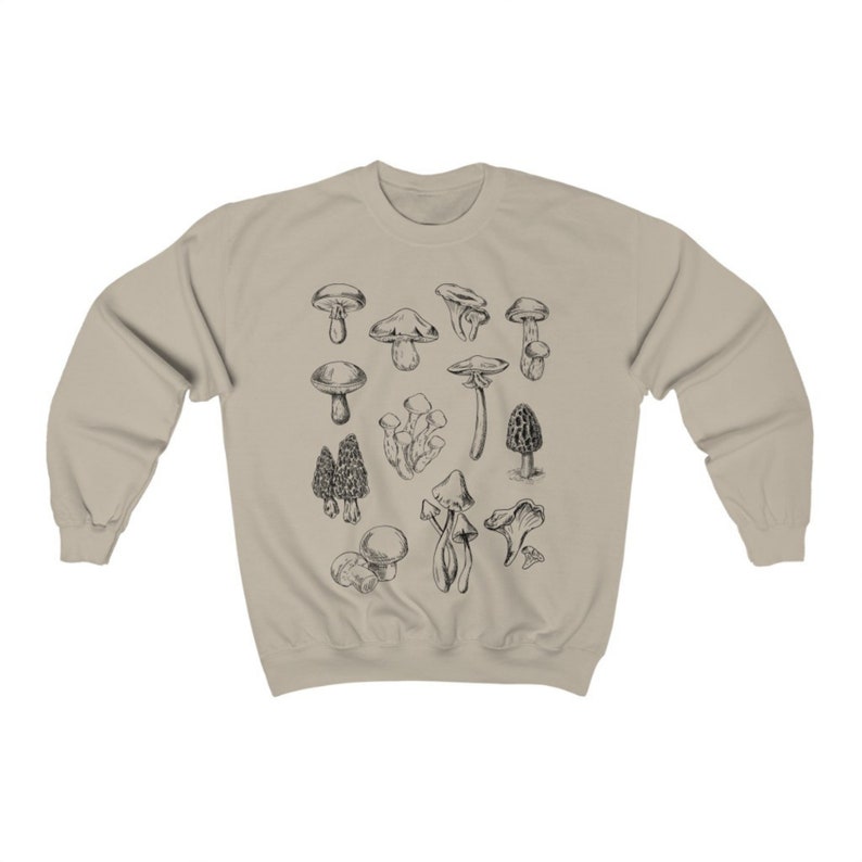 May include: A beige sweatshirt with a black and white illustration of various types of mushrooms.