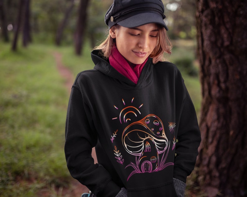 May include: Black hoodie with a graphic of a mushroom house with a sun and flowers in a rainbow color scheme.