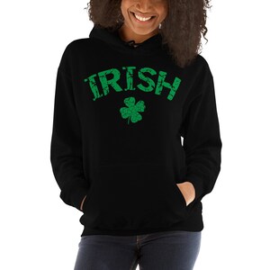 Puede incluir: Sudadera con capucha negra con un texto "IRISH" verde desgastado y un tr&eacute;bol de cuatro hojas verde.