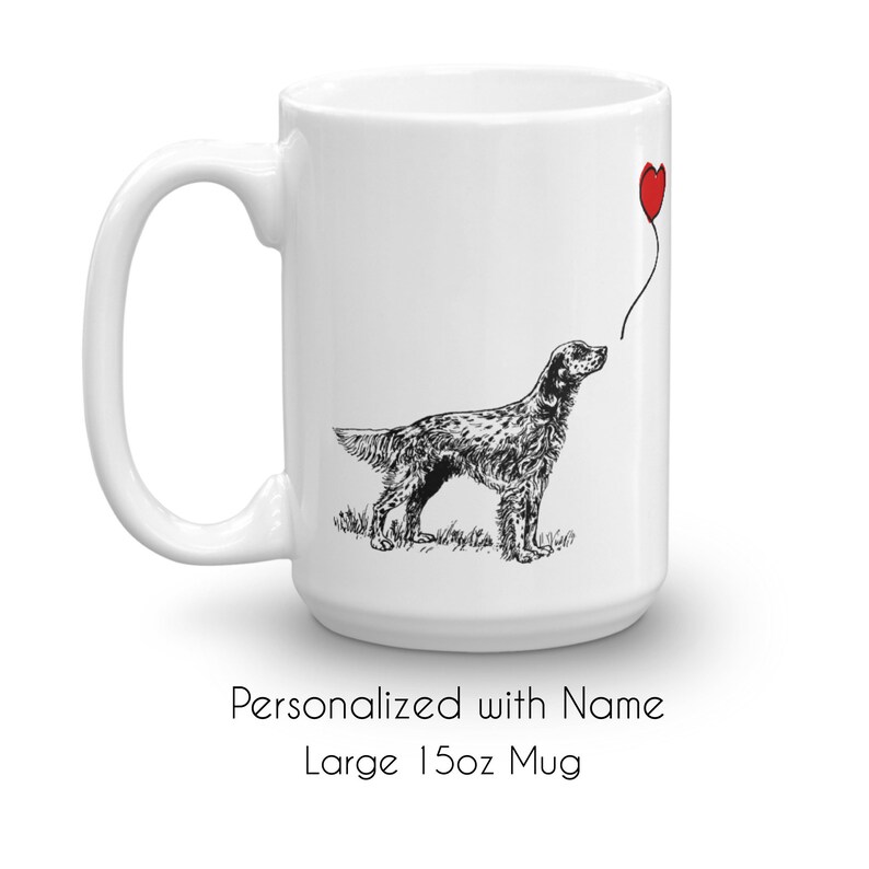 May include: White ceramic mug with a black and white illustration of a dog holding a red heart balloon. The mug is 15 ounces and says "Personalized with Name" and "Large 15oz Mug" on the bottom.