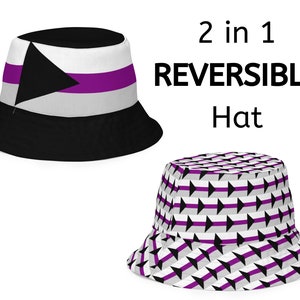 May include: A reversible bucket hat with two designs. One side features a black and white geometric pattern with purple accents. The other side features a black triangle on a white background with a purple stripe.