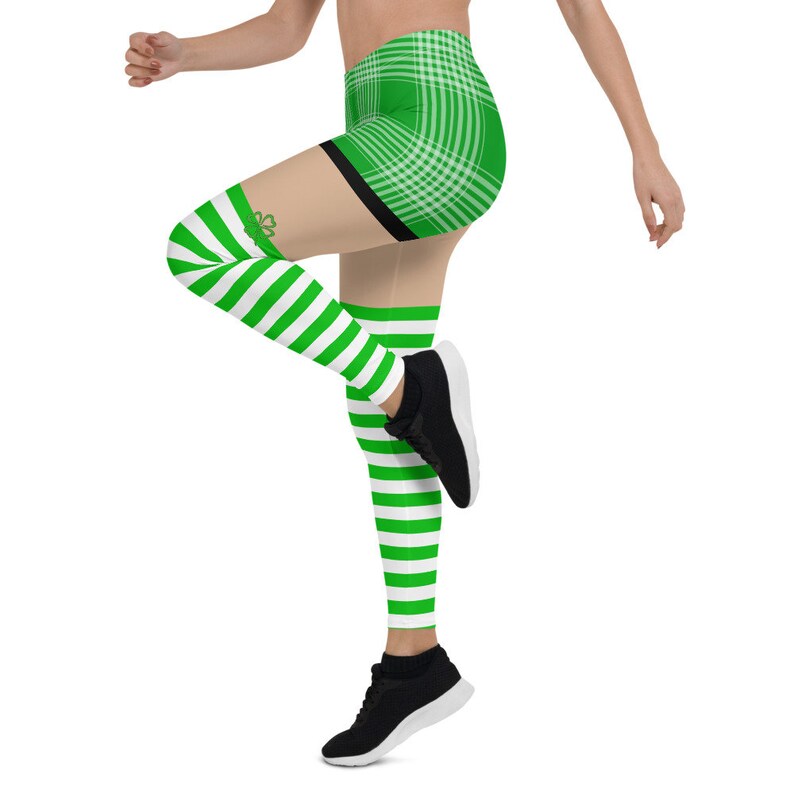 May include: Green and white striped leggings with a green plaid waistband and a shamrock design on the thigh. The leggings are worn with black sneakers.