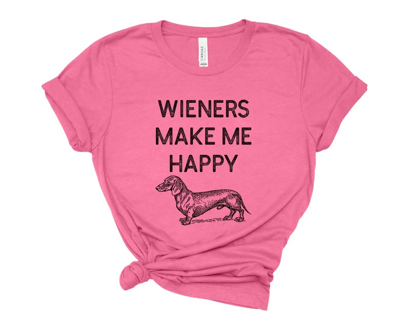 Puede incluir: Camiseta rosa con una ilustraci&oacute;n de dachshund y el texto "Wieners Make Me Happy".
