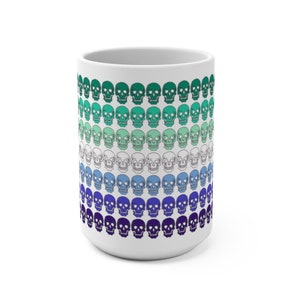 May include: White ceramic mug with a pattern of skulls in shades of green, blue, and purple. The skulls are arranged in rows, with the colors gradually transitioning from green to purple.