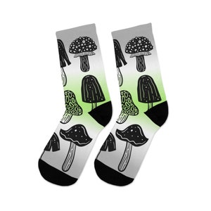 May include: A pair of black and white socks with a gradient design of green and white. The socks feature a repeating pattern of mushrooms.