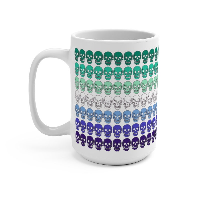 May include: White ceramic mug with a pattern of skulls in shades of green, blue, and purple. The skulls are arranged in rows, with the colors gradually transitioning from green to purple.