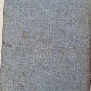 May include: A light blue book cover with a textured fabric surface. The cover has a few small brown spots.