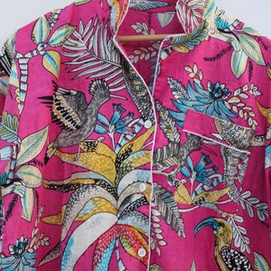 Peut inclure: Un haut de pyjama rose vif avec un imprim&eacute; botanique et d'oiseaux. Le haut &agrave; manches longues pr&eacute;sente une fermeture boutonn&eacute;e, une poche poitrine et une bordure blanche. L'imprim&eacute; comprend des oiseaux, des feuilles et des fleurs de diff&eacute;rentes couleurs.