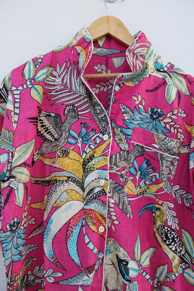 Peut inclure: Un haut de pyjama rose vif avec un imprim&eacute; botanique et d'oiseaux. Le haut &agrave; manches longues pr&eacute;sente une fermeture boutonn&eacute;e, une poche poitrine et une bordure blanche. L'imprim&eacute; comprend des oiseaux, des feuilles et des fleurs de diff&eacute;rentes couleurs.