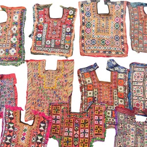 Może przedstawiać: Kolekcja żywych, haftowanych topów. Każdy top ma skomplikowane wzory z geometrycznymi i kwiatowymi motywami w odcieniach czerwieni, pomarańczy, różu, błękitu i zieleni. Top ma kwadratowe dekolty i prawdopodobnie jest w stylu vintage lub ręcznie robiony.