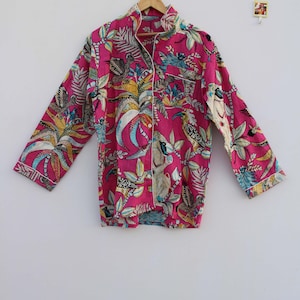 Peut inclure: Un haut de pyjama rose vif avec un imprim&eacute; botanique et d'oiseaux. Le haut &agrave; manches longues pr&eacute;sente une fermeture boutonn&eacute;e, un col crant&eacute; et une bordure blanche. Le tissu est orn&eacute; d'illustrations color&eacute;es d'oiseaux et de feuillage tropical.