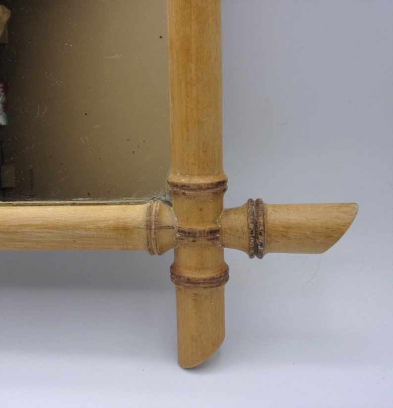 Puede incluir: Un espejo de madera con un marco de bamb&uacute;. El marco est&aacute; hecho de bamb&uacute; natural de color marr&oacute;n claro. El espejo es rectangular y tiene un borde biselado.