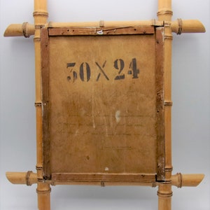 Puede incluir: Un marco de fotos de madera de bamb&uacute; con un respaldo de papel marr&oacute;n. El marco mide 50 x 24 pulgadas y tiene una nota manuscrita en la parte posterior.
