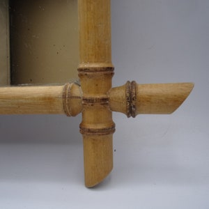 Puede incluir: Primer plano de un marco de espejo de madera hecho de bamb&uacute;. El marco es de color natural y tiene un dise&ntilde;o sencillo.