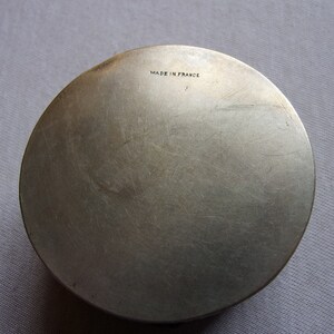 May include: A silver round metal box with the words "Made in France" engraved on the bottom.