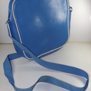 May include: A blue leather shoulder bag with a white trim and a long adjustable strap.