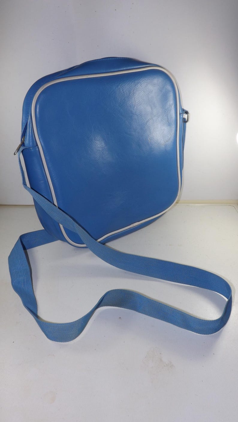 May include: A blue leather shoulder bag with a white trim and a long adjustable strap.