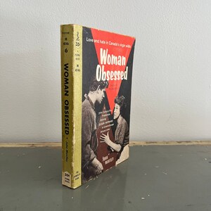May include: A vintage paperback book titled "Woman Obsessed" with a red and white cover featuring a photo of two people. The book is part of a series called "The Complete Film Books" and is priced at 35 cents.
