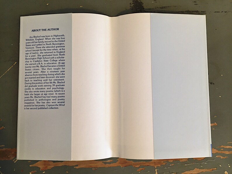 May include: A white book with a blue spine and the text "About the Author" on the front cover. The text describes the author's life and career, including her education, teaching experience, and writing.