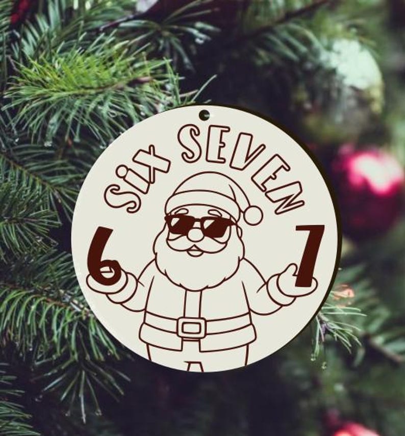 May include: A circular, cream-coloured Christmas ornament with a cartoon Santa Claus wearing sunglasses. The text "SIX SEVEN" is arched above the Santa illustration, with the numbers 6 and 7 on either side. The ornament has a hole for hanging.