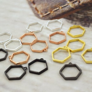 May include: Assortment of hexagon-shaped metal pendant blanks in silver, gold, and rose gold finishes. The blanks are perfect for creating custom jewelry.