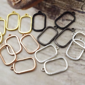 Puede incluir: Surtido de 12 bandejas colgantes de metal dorado, plateado y negro con borde biselado. Las bandejas son rectangulares y tienen un pequeño bucle en la parte superior para colgar.