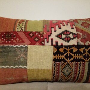 May include: A rectangular patchwork pillow with a variety of colors and patterns, including red, green, beige, and black. The pillow is made of woven fabric and has a traditional design.