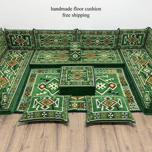 May include: A handmade green floor cushion set with geometric patterns in orange, white, and black. The set includes large cushions, a square table, and two smaller pillows. The text "handmade floor cushion" is visible.