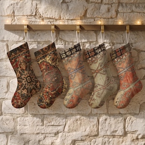 May include: Five Christmas stockings hanging from a wooden rail, each featuring a unique woven pattern reminiscent of traditional rug designs. The stockings display a variety of colours including deep red, dark green, beige, and orange tones.