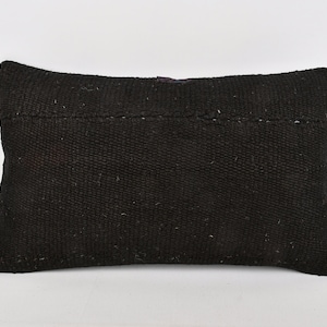 May include: A black rectangular pillow with a woven texture. The pillow is made of a thick, durable material and has a simple, modern design.