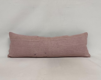 May include: A long, rectangular, dusty rose-colored pillow with a subtle woven texture.