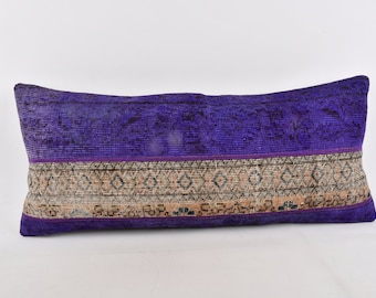 May include: A rectangular decorative pillow with a vibrant purple top and bottom, and a patterned center band. The pillow's design features a mix of colors, including purple, beige, and black, creating a visually appealing accent piece.