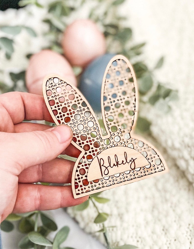 Op de afbeelding: Houten paas konijn plaatskaart met een uitgesneden ontwerp en de naam "Blakely" gegraveerd aan de onderkant.