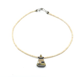 May include: A white shell bead necklace with a geometric, multi-colored stone pendant.