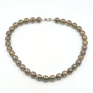 May include: A silver necklace with round beads. The beads are slightly textured and have a slightly aged look.