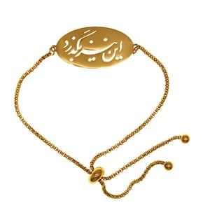 Puede incluir: Pulsera dorada con un centro ovalado con texto grabado. La pulsera tiene un diseño de cadena delicada y un cierre deslizante ajustable. El texto está en una escritura estilizada. La pulsera se muestra sobre un fondo blanco.