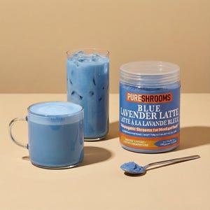 May include: Three glasses of light blue beverage, possibly a latte, with ice, and a container of "Blue Lavender Latte" powder. A spoon with powder is also present. The product is labeled "PureShrooms". The image suggests a health drink.