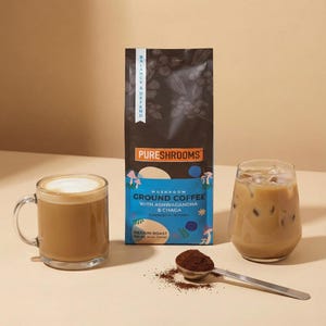 May include: An image showcases a bag of PURESHROOMS mushroom ground coffee with ashwagandha and chaga, a mug of coffee with foam, and a glass of iced coffee. A spoon holds coffee grounds. The bag reads "BALANCE & DEFEND".