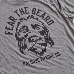 May include: Gray t-shirt with a black graphic of a dog's face in a circle with the text "Fear the Beard" and "Palouse Prairie Co."